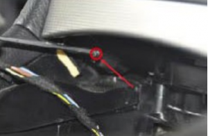 Use a screw driver to remove the screw marked with a red circle