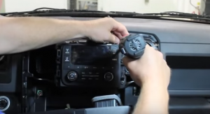 Remove the four screws that secure the vehicle’s radio to the dashboard