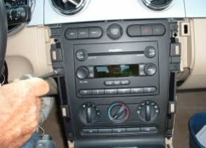 Remove bolts securing radio bezel and AC controls
