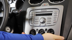 Carefully pry the plastic trim plate with both of your hands, which is in front of the place where the old car radio is situated