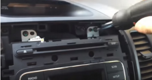 Remove four screws holding the factory radio in place with a screwdriver