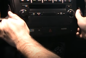 Release the radio cover panel and unplug the connector behind