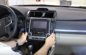 Once the four radio mounting screws have been removed, gently lift the radio from the dashboard in order to gain access to the factory wiring harnesses on the backside