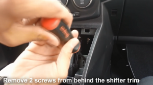 Remove two screws from behind the shifter trim