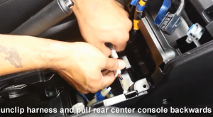 Unclip harness and pull rear center console backwards
