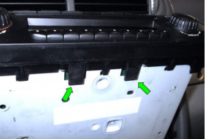 Here is a close-up of the underside of the stereo. These two plastic fingers (green arrows) fit into the tabs on the top edge of the lower tray