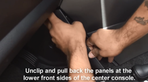 Unclip and pull back the panels at the lower front sides of the center console