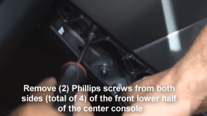 Remove two Phillips screws from both sides(total of four) of the front lower half of the center console