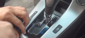 Pry the shifter surround panel. On manual transmission vehicles, unclip and reposition the shifter. Then remove the panel