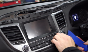 Use the plastic removal tool to pry the car radio trim panel