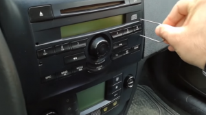 Insert the release keys into the holes of the original car radio