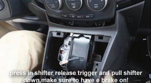 Press in shifter to release trigger and pull shifter down, make sure to have a brake on