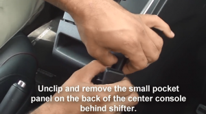 Unclip and remove the small pocket panel on the back of the center console behind shifter