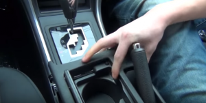 Remove the panel on downside of the e-brake. Please make sure your e-brake is up