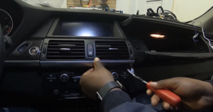 Use a pry tool to pry loose the air vent dash trim