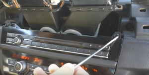 Use a screwdriver to remove the screws that fix the original car radio panel