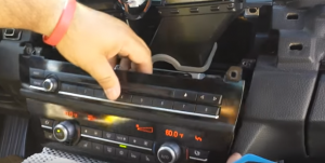 Remove the car radio panel and then disconnect the connectors at the back of it