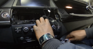 Use a screwdriver to remove the two screws that fix the original car radio dash trim