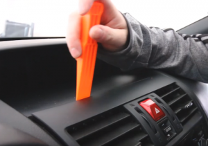 Use a plastic removal tool to pry the trim panel of the original car radio