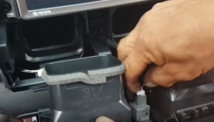 Disconnect the connector at the back of the air vent